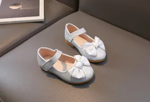 Detail van meisjes Mary Jane schoen met grote witte strik en rubberen zool