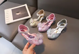 Close-up of glittery girls' princess shoes with rhinestone bows in multiple colors
