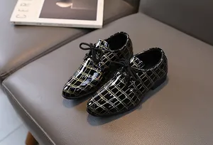 Details von Schnürschuhen für Jungen aus schwarzem Lackleder mit goldenen Texturen