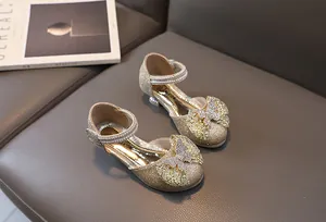 Detailed macro view of girls gold sequin princess shoes with rhinestone bow detail