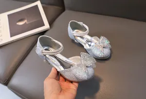 Detail of silver sequin Mary Jane shoes with rhinestone bow and fashion glitter finish