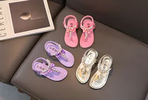 Dettaglio dei sandali infradito per bambine con perle finte e fiocchi in tre colori vivaci