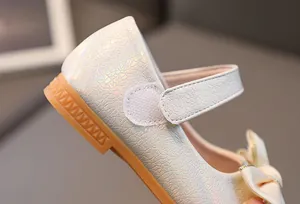 Detail van Mary Jane-schoenen voor meisjes met parelmoerglans en strikdecoratie