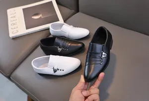 Détail de chaussures en cuir pour garçons noires et blanches avec boucle en métal