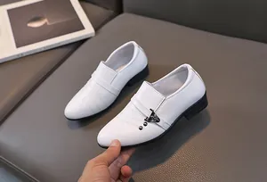 Détail de chaussures habillées blanches pour garçon avec boucles et coutures soignées
