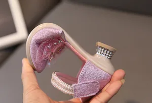 Detail of pink glitter girls princess heel with pearl strap and bow lace decoration