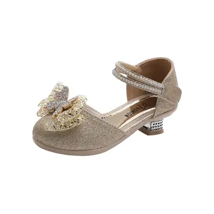 Detail of gold crystal princess shoe featuring rhinestone bow and pearl strap