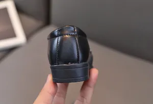 Gros plan de chaussures de soirée noires pour garçons avec double couture et talon renforcé