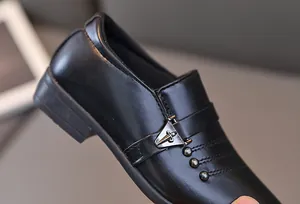 Vue détaillée de chaussures de cérémonie noires pour garçon avec boucle en métal et perles