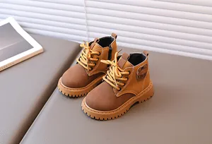 Detail view of children's tan work boots with side zipper and thick non-slip rubber soles