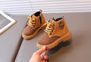 Detail view of boys brown boots featuring side zippers and non-slip rubber soles