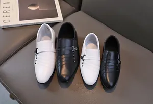 Gros plan de mocassins pour garçons en cuir noir et blanc avec boucles métalliques