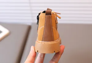 Detail of yellow toddler work boots showing the non-slip thick sole and rear zipper design