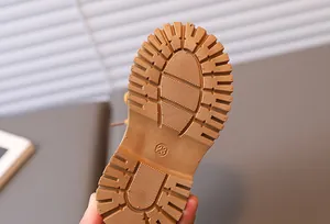 Detailed macro view of the non-slip rubber sole with tread patterns on boys yellow boots