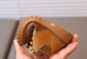 Close-up of flexible yellow toddler boots showing soft leather and non-slip rubber soles