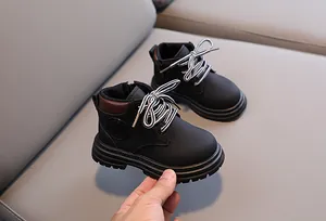 Detailed side view of kids black combat boot with striped laces and fashion badge