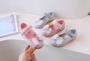 Detail of girls' princess shoes with pink glitter, mesh bow, and pearl strap decoration