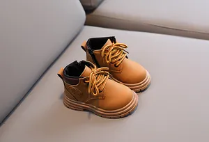 Overhead view of yellow children boots with fashion logo and grippy rubber soles