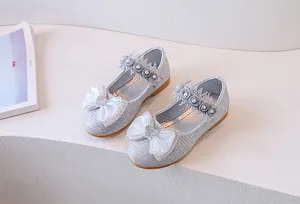 Detail of silver sparkling princess shoes with lace, pearls and a rhinestone heart bow