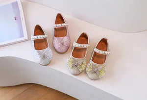 Detalle de zapatos Mary Jane de purpurina para niña con lazos de strass y perlas