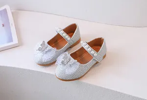 Detalle de zapatos de princesa plateados con lentejuelas, perlas y adorno de lazo