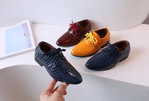 Détail de chaussures Oxford vernies pour garçons avec relief crocodile et lacets