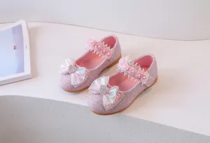 Detail of pink sequin girl's shoe with heart rhinestone, bow, and lace floral pearls