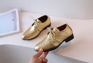 Close-up of golden embossed leather boys shoes with textured crocodile pattern