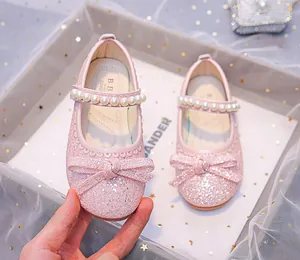Close-up of pink glitter Mary Jane shoes for girls with pearl strap and bow detail
