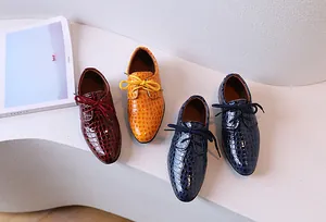Gros plan de chaussures habillées pour garçons en cuir verni avec texture crocodile