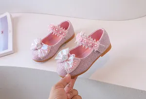 Detail of pink sequin princess shoes with large bow, lace trim and pearl accents
