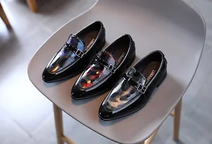 Détail de chaussures de ville pour garçons avec boucles monk strap et finitions vernies