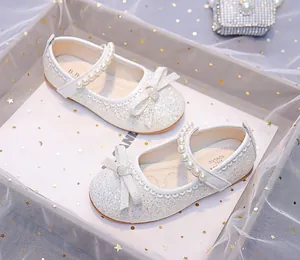 Detail of silver glitter Mary Jane shoes with bow and pearl strap for young girls