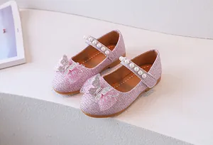 Detalle de zapatos Mary Jane rosa con purpurina para niña con lazo brillante y tira de perlas