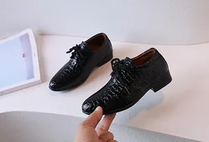 Detail of boys' black faux crocodile leather oxford shoe with glossy patent finish