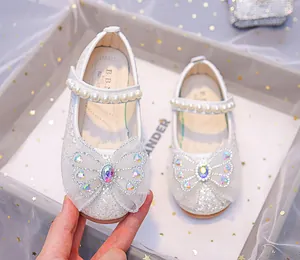 Détail de chaussures Mary Jane argentées à paillettes avec nœud strass et bride perle