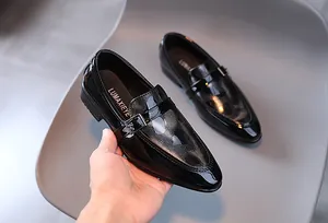 Détail de chaussures en cuir verni noir pour garçons avec tige texturée et boucle métallique