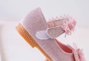 Close-up of pink glitter girl princess shoes with lace floral details and pearls