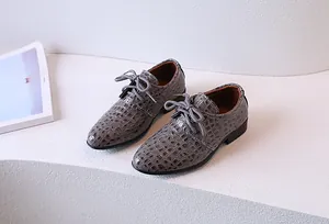 Close-up of boys gray Oxford shoes featuring stylish crocodile embossed texture