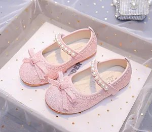 Detail of pink glitter girls' Mary Jane shoes with pearl strap and bow ornament