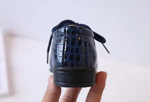 Vue détaillée du cuir gaufré crocodile bleu foncé et de la semelle en caoutchouc pour garçon