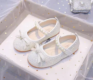 Detailed view of silver sequin Mary Jane shoes for girls with bow and pearl strap decoration