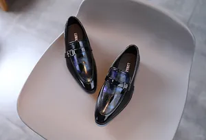 Détail de chaussures vernies pour garçons avec motif iridescent et boucle métallique chic