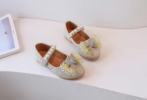 Primer plano de zapatos Mary Jane de lentejuelas oro champán con perlas y strass brillante
