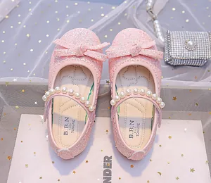Detailed view of pink sequin Mary Jane shoes with pearls, bow, and lace trim details
