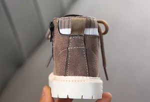 Nahaufnahme brauner Kinderstiefel aus Wildleder mit Reißverschluss und Strickkragen