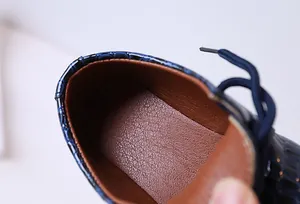 Détail du similicuir bleu marine à motif crocodile et doublure brune pour chaussures garçons