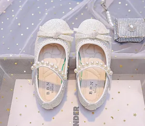 Top view of girls' white sequined Mary Jane shoes with pearls and bow decoration