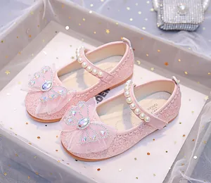 Détail de chaussures roses à paillettes pour filles avec nœud en cristal et perle