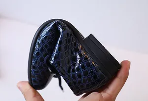Détail de la semelle souple et de la texture crocodile sur les chaussures garçon